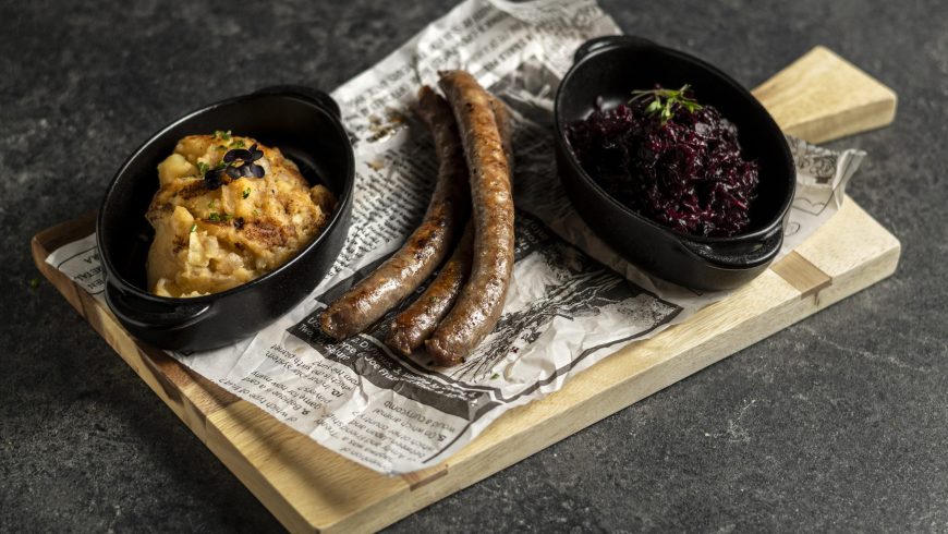 Bavarian baked sausage with stewed cabbage and potato mash with fried onion