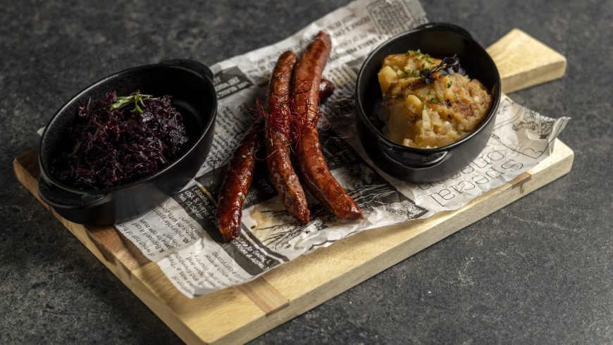 Spicy baked sausage with stewed cabbage and potato mash with fried onion