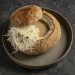 Creamy garlic soup with parmesan chips in a loaf