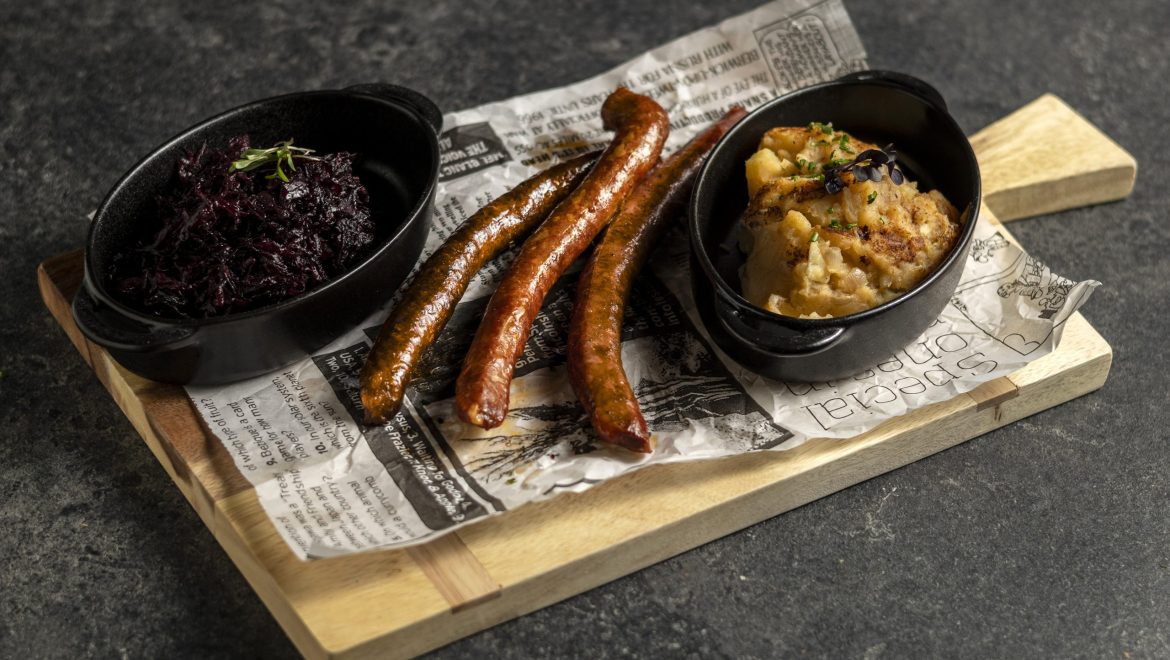 Classic baked sausage with stewed cabbage and potato mash with fried onion