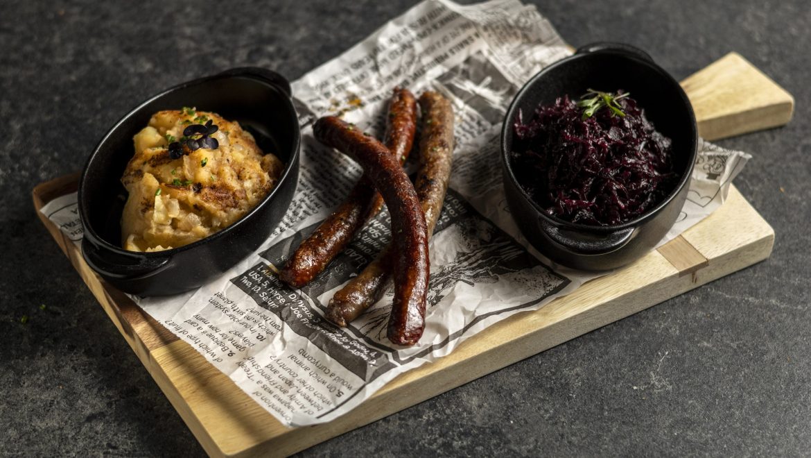 Baked sausage selection with stewed cabbage and potato mash with fried onion